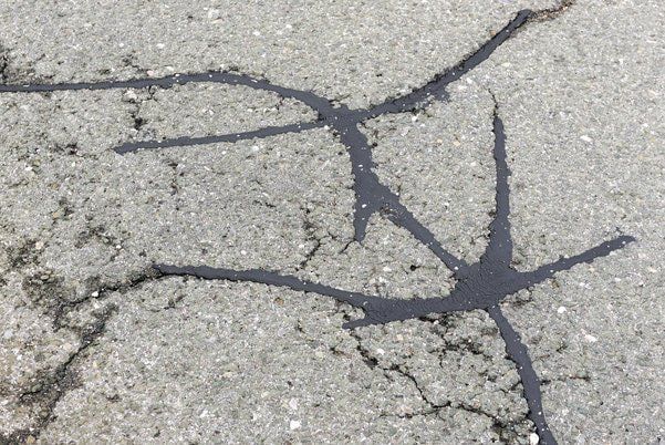 Asphalt road with filled cracks. background of the fixed road and an asphalt road surface with cracks repaired