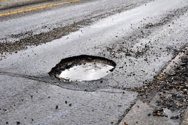 A pothole filled with water on an asphalt street in columbus ohio