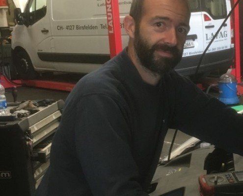 Ein Mann mit Bart sitzt vor einem weißen Lieferwagen mit der Aufschrift „Launch“