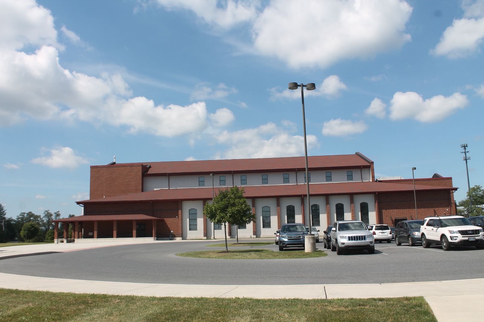A large building with a lot of cars parked in front of it