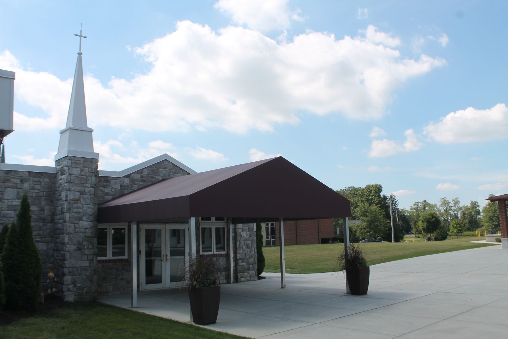 A church with a white steeple and a brown awning