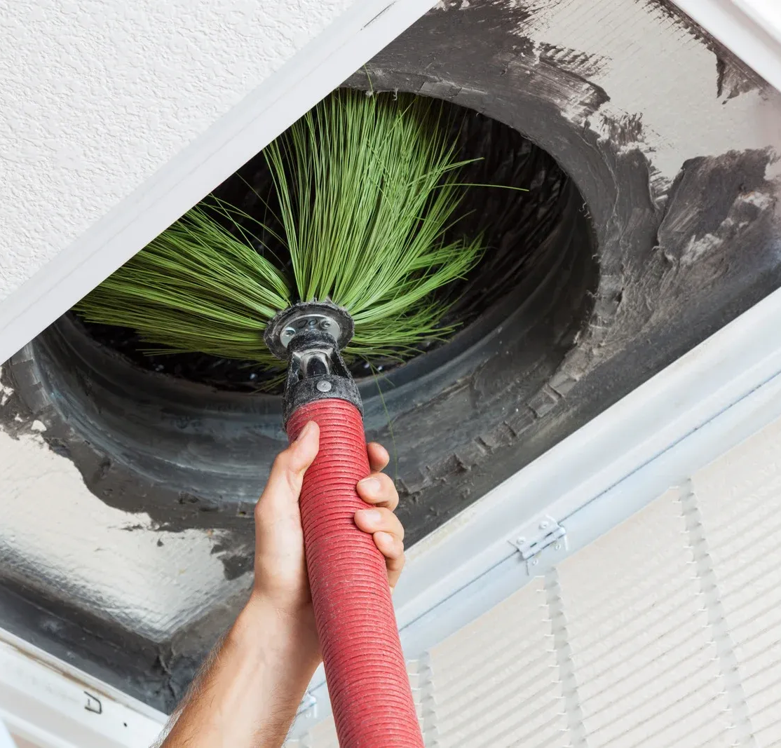A yellow excavator is sitting on top of a pile of gravel.