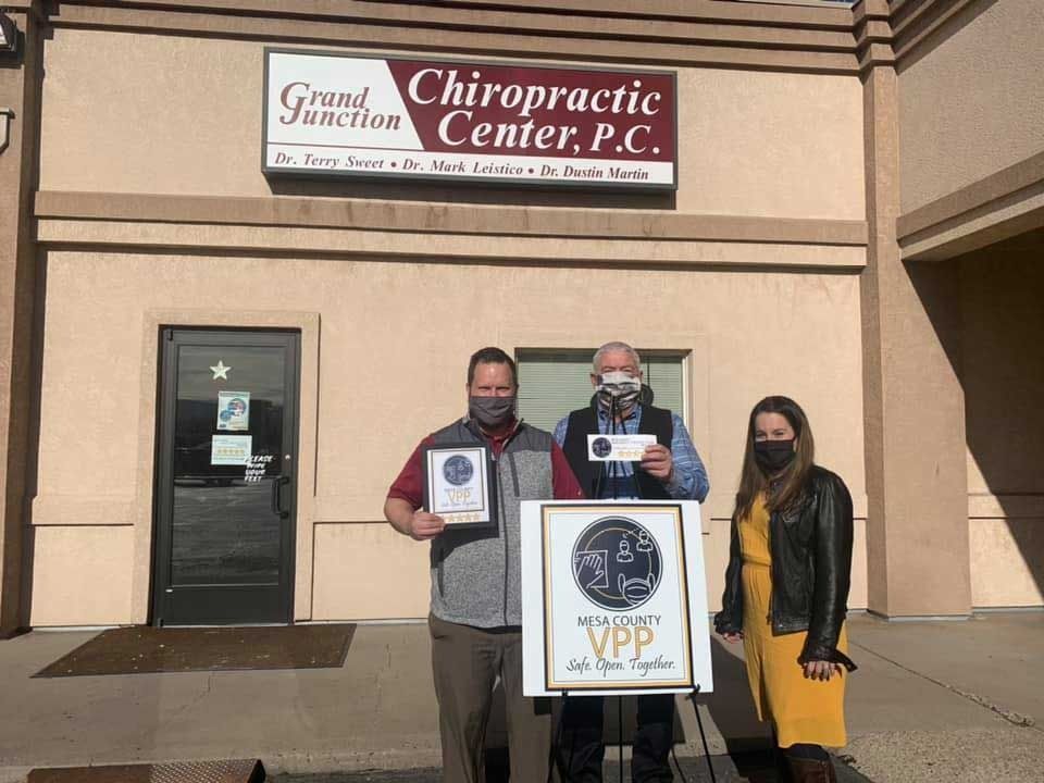 A group of people standing in front of a chiropractic center.