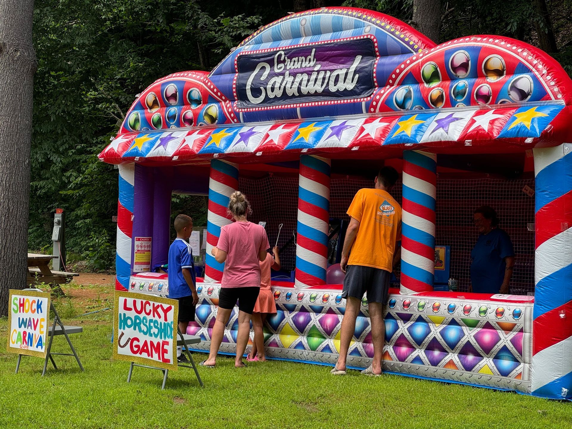 A group of people are standing in front of an inflatable carnival.