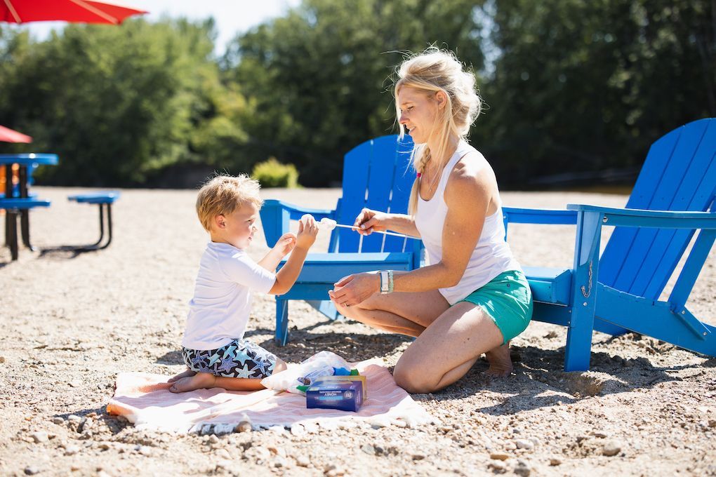 A woman and a child are playing in the sand on the beach.
