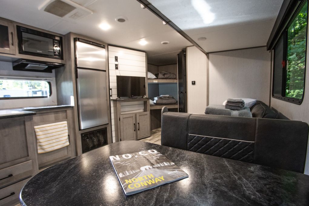 The inside of a rv with a table and couch.