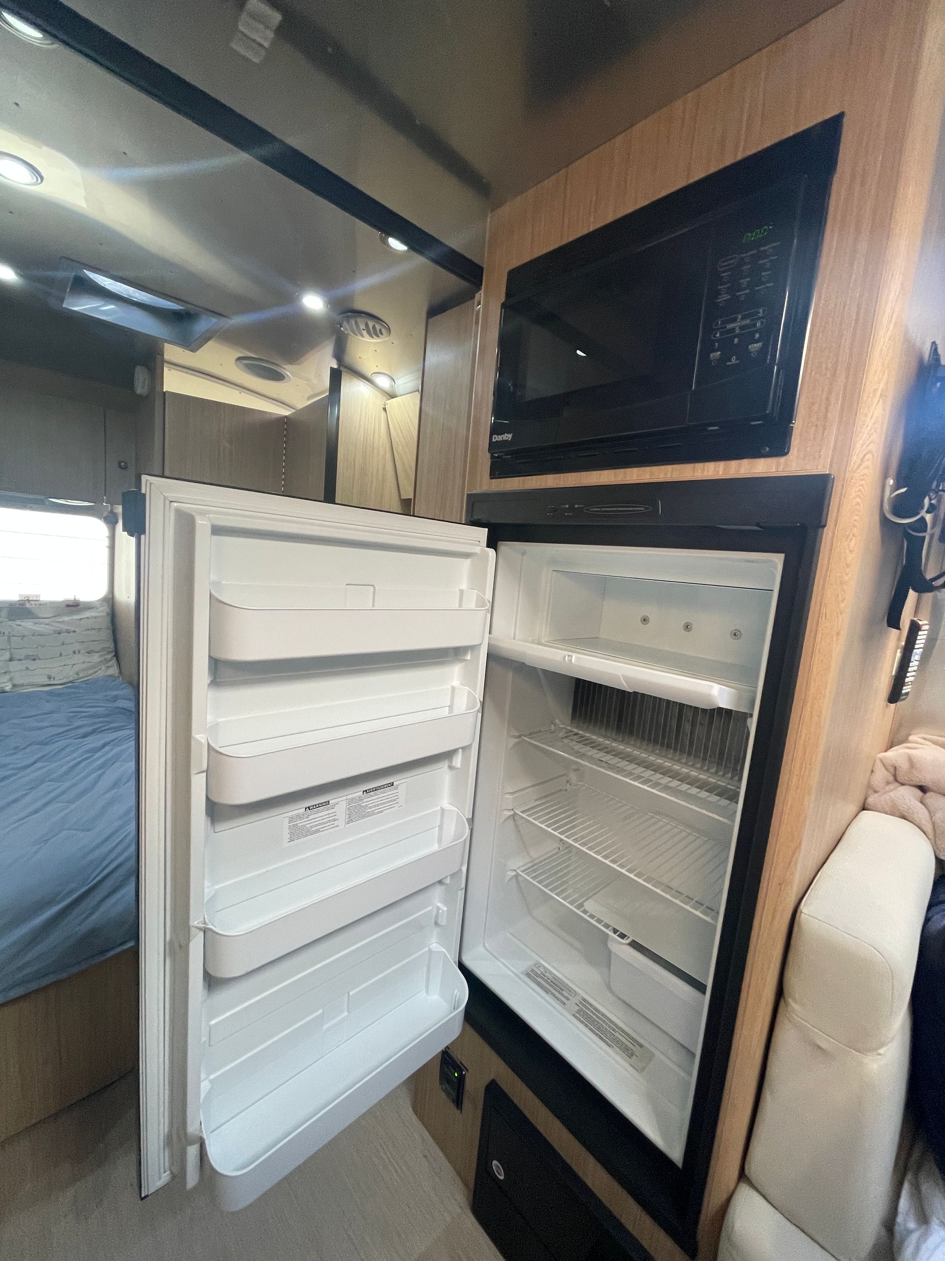 A refrigerator in a camper with the door open