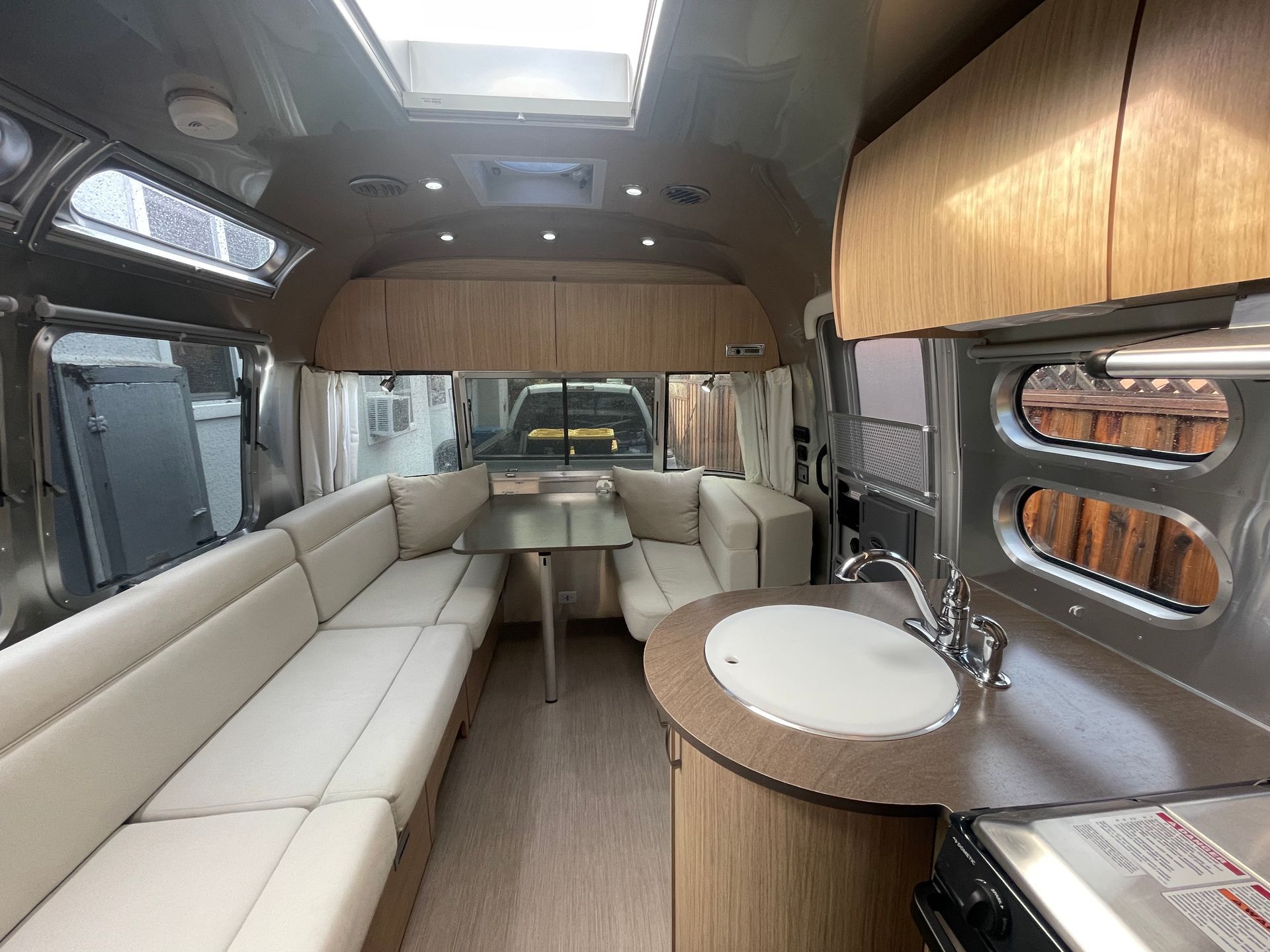The inside of an airstream with a couch , table and sink