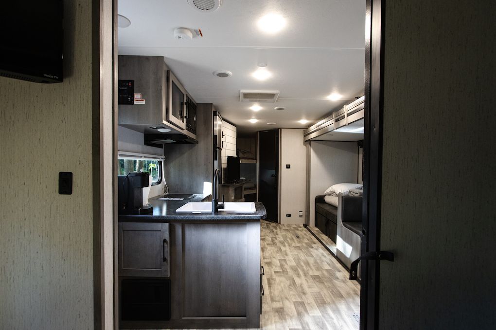 A black and white photo of a kitchen in a rv.