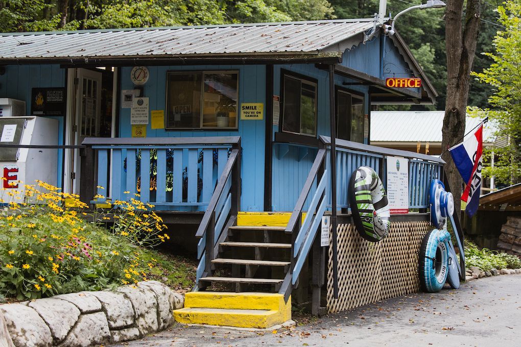A blue building with stairs leading up to it and a sign that says ' office ' on it.