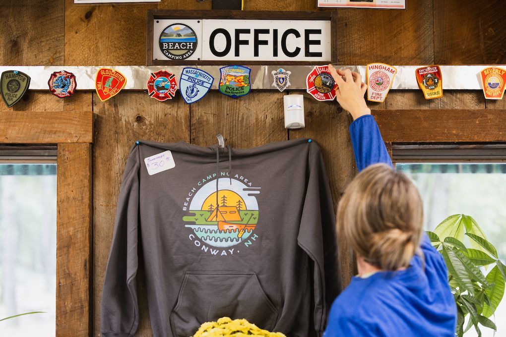 A woman is standing in front of a sign that says office.