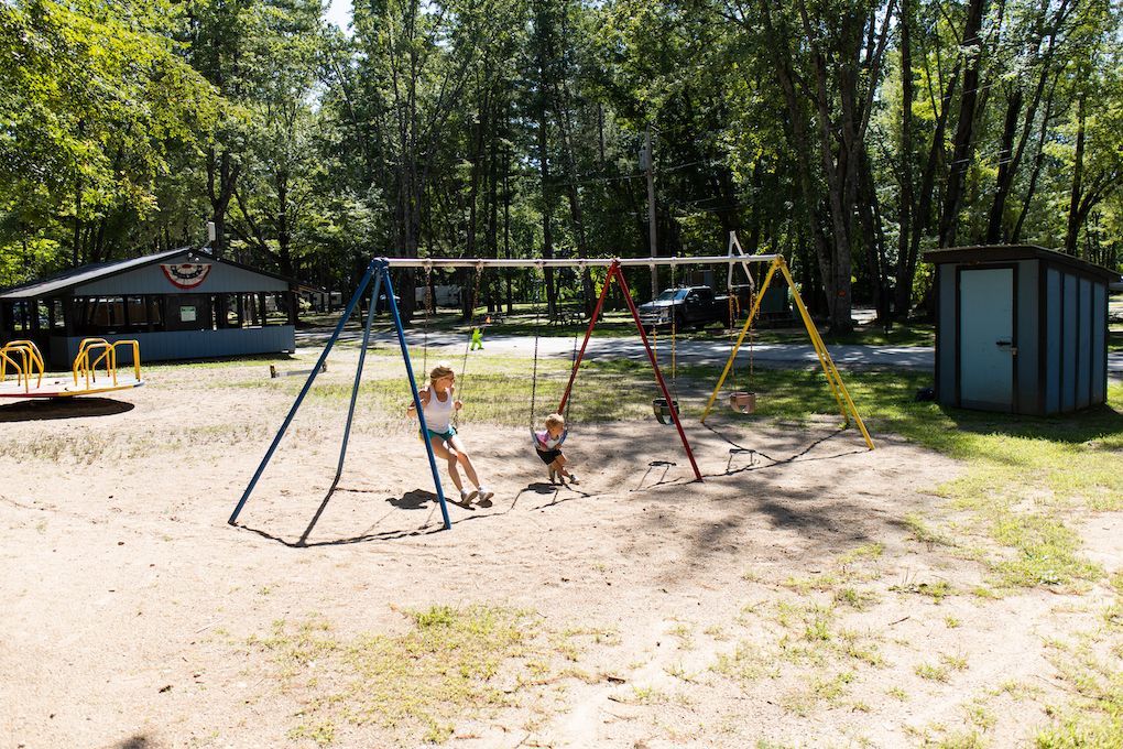 A group of children are playing on swings in a park.