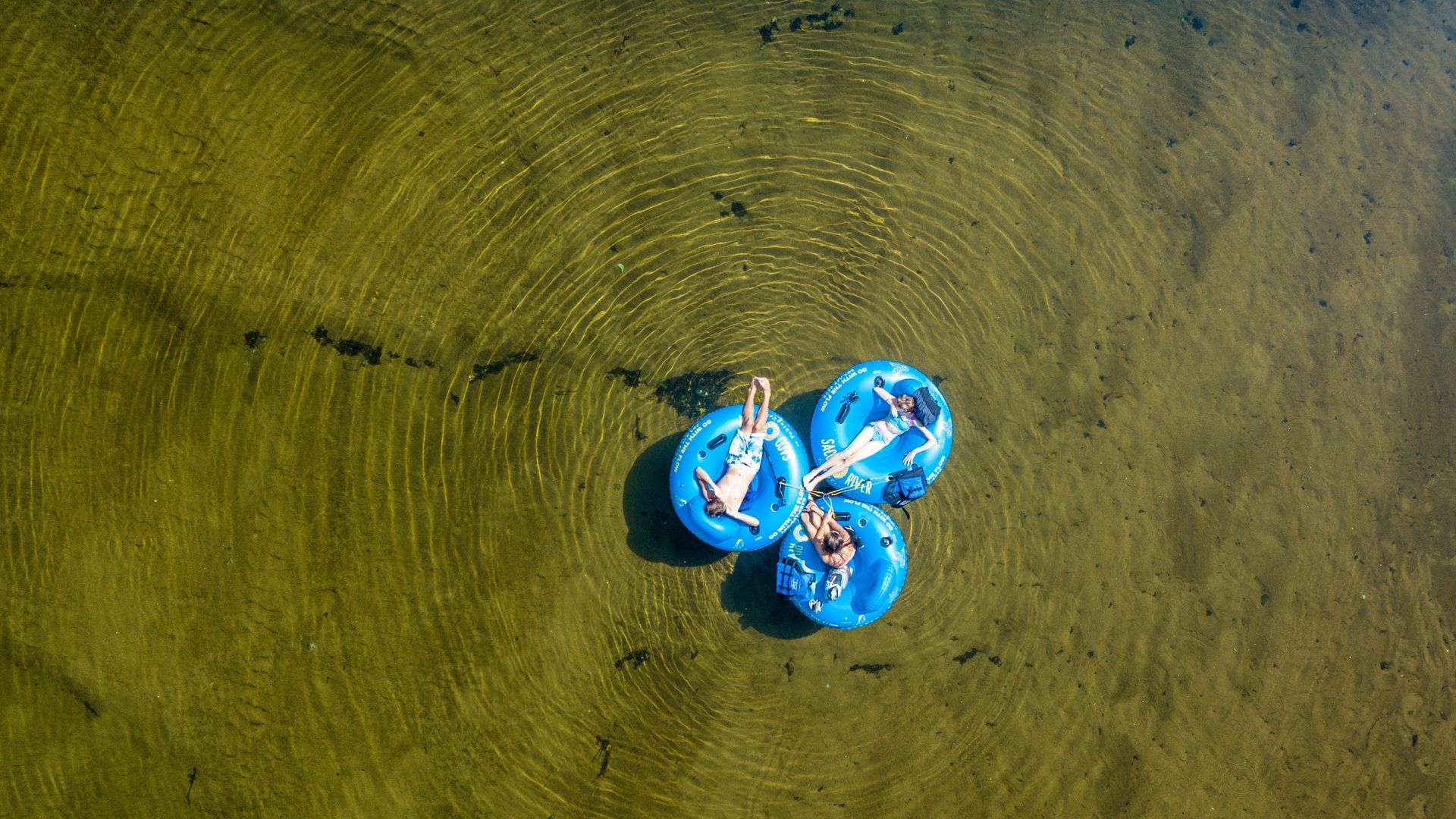 A group of people are floating on rafts in the water.
