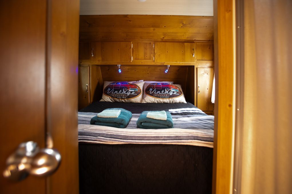 A bedroom with a bed and a door leading to it.