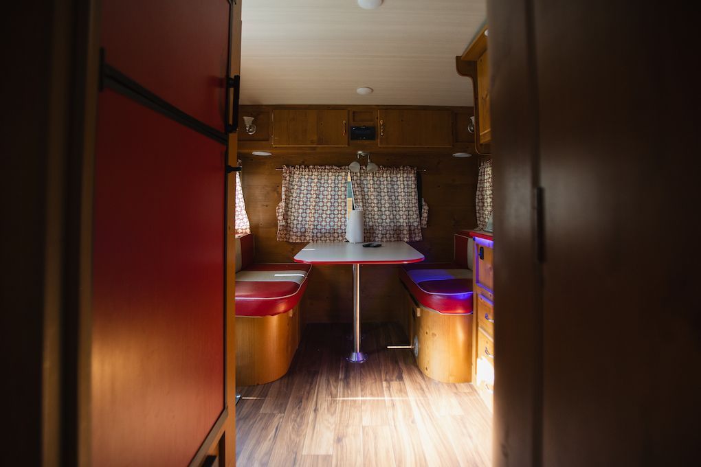 A camper with a table and chairs inside of it.