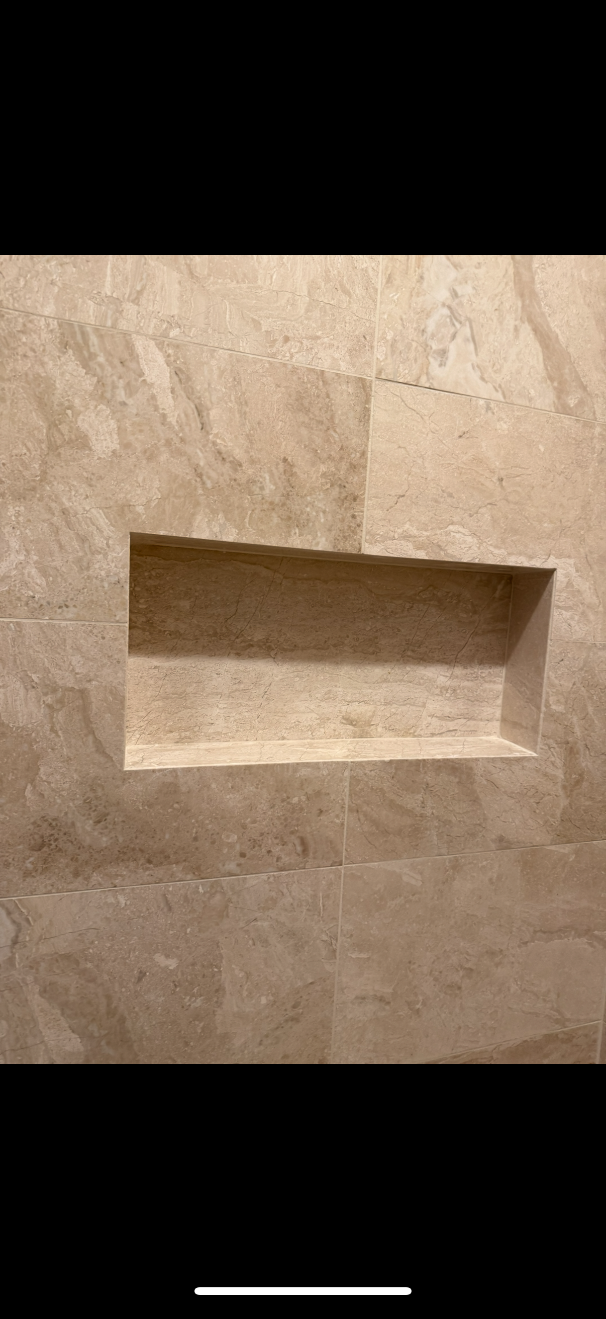A shelf is built into a tile wall in a bathroom in East Brunswick, NJ.