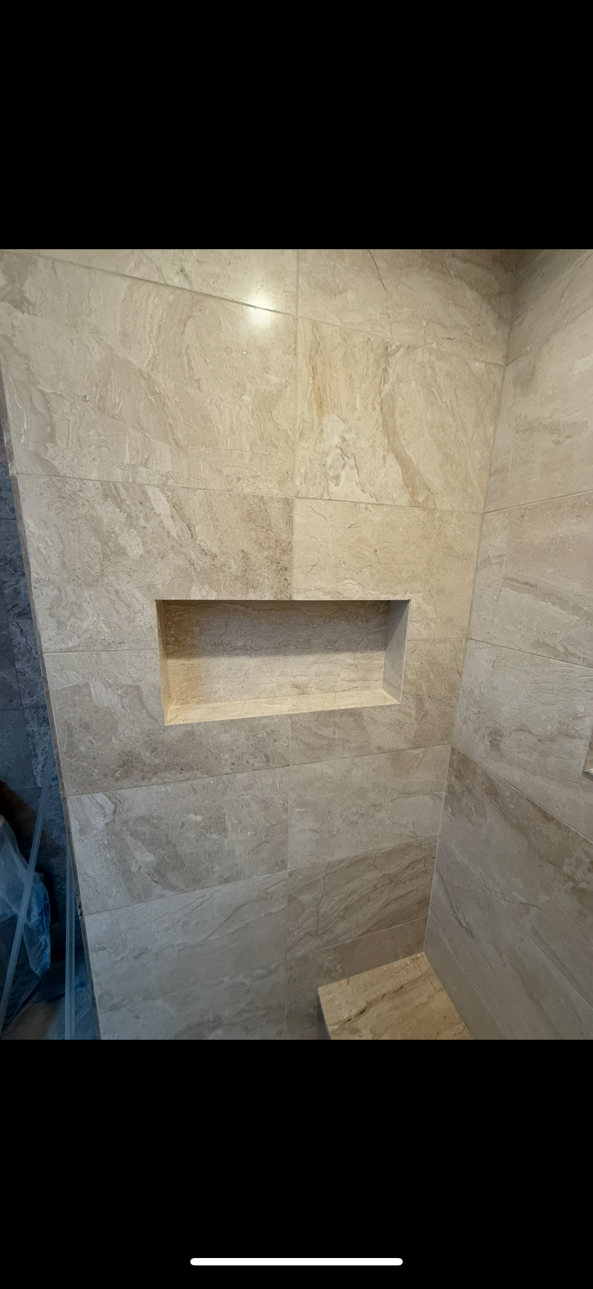 A bathroom with a newly tiled shower stall and a shelf in the wall in Old Bridge, NJ.