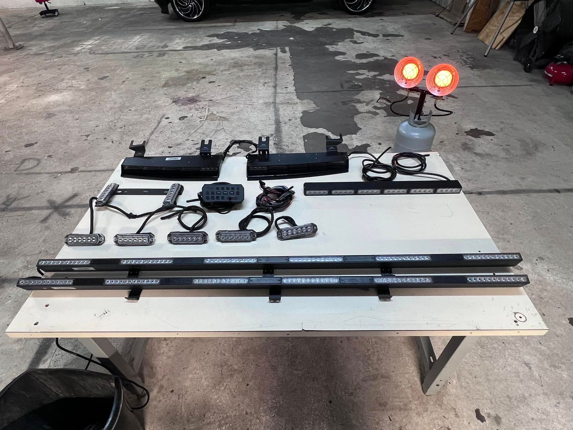 Emergency vehicle light kit on a table with two orange lights in the background.