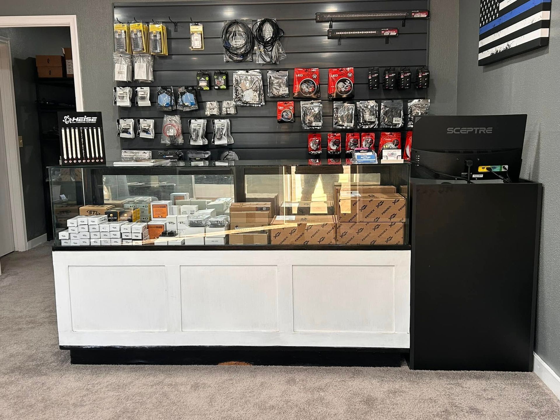A retail shop interior with display shelves of products and a black and white counter.