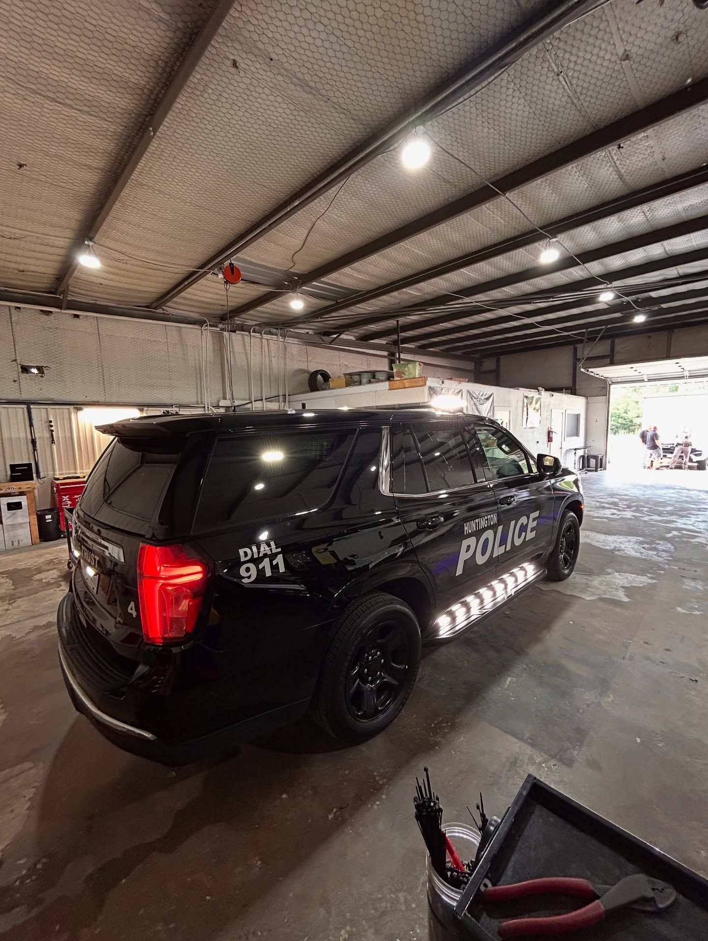Black police SUV parked inside a garage; 