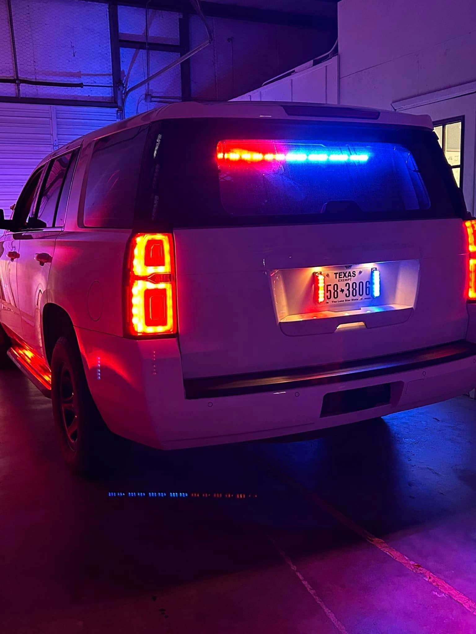 White police SUV with flashing red and blue lights.