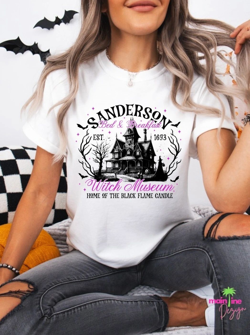 A woman is wearing a white t-shirt with a haunted house on it.