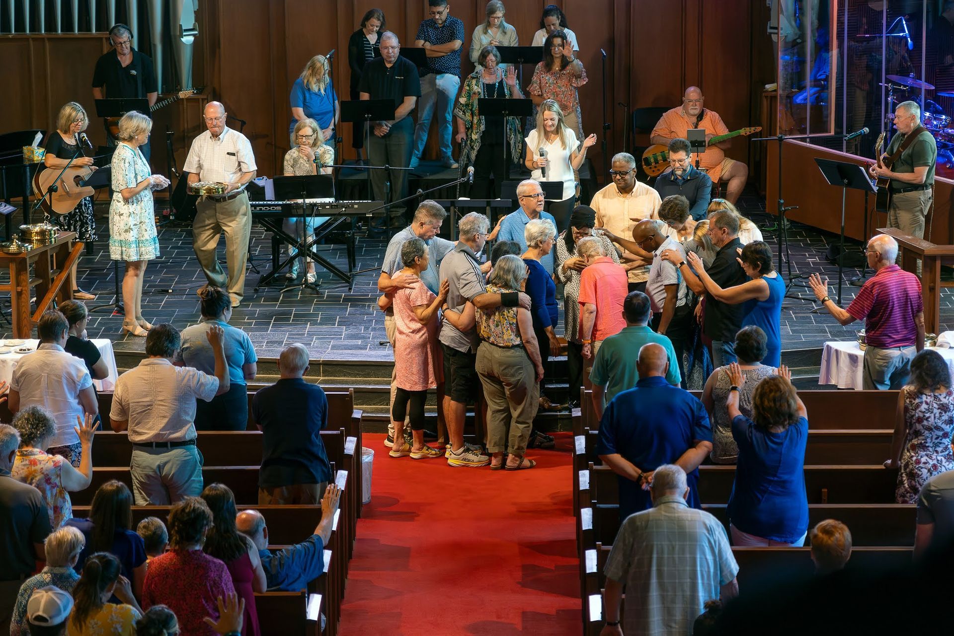 A large group of people are standing on a red carpet in a church.