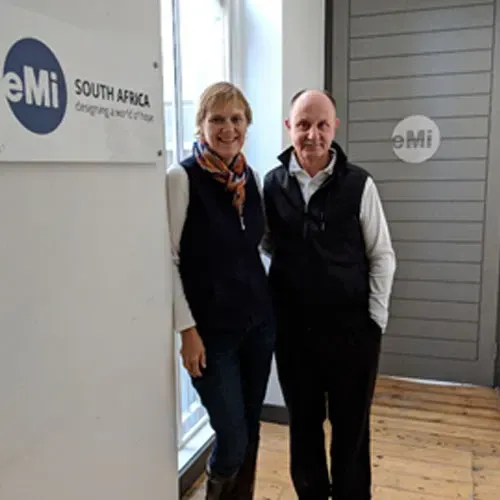 A man and a woman are standing next to each other in front of a south africa sign.