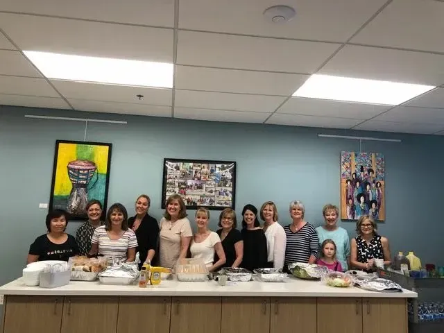 A group of women are posing for a picture in a kitchen