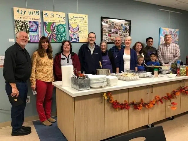 A group of people are posing for a picture in front of a buffet table.