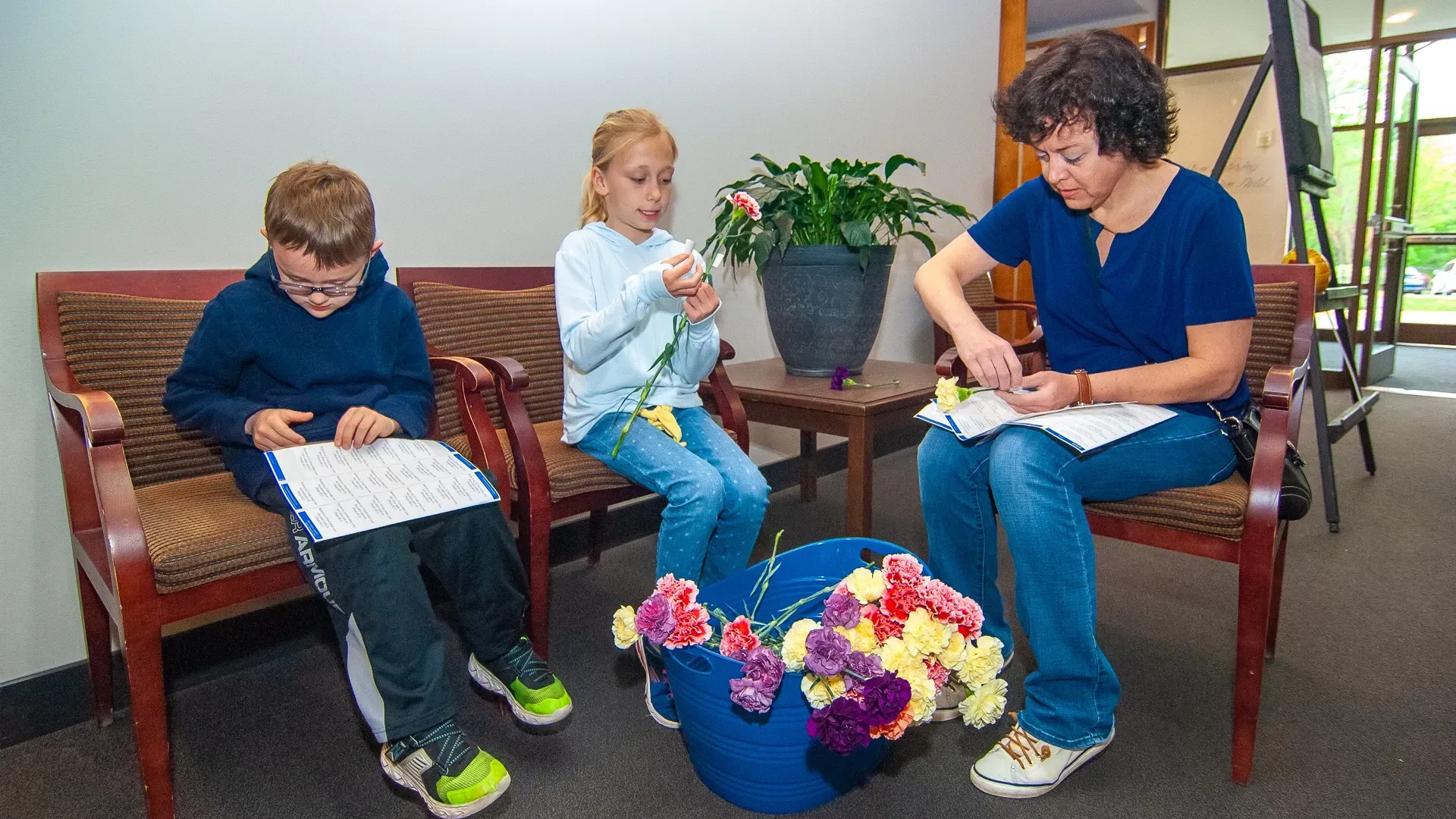 A woman and two children are sitting in a waiting room