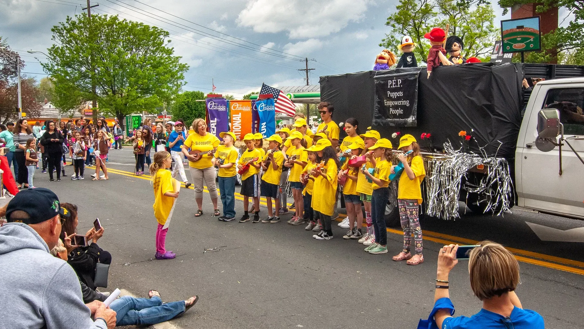 A group of children are standing in front of a float in a parade.