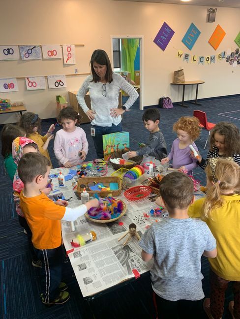 A group of children are sitting around a table playing with toys.