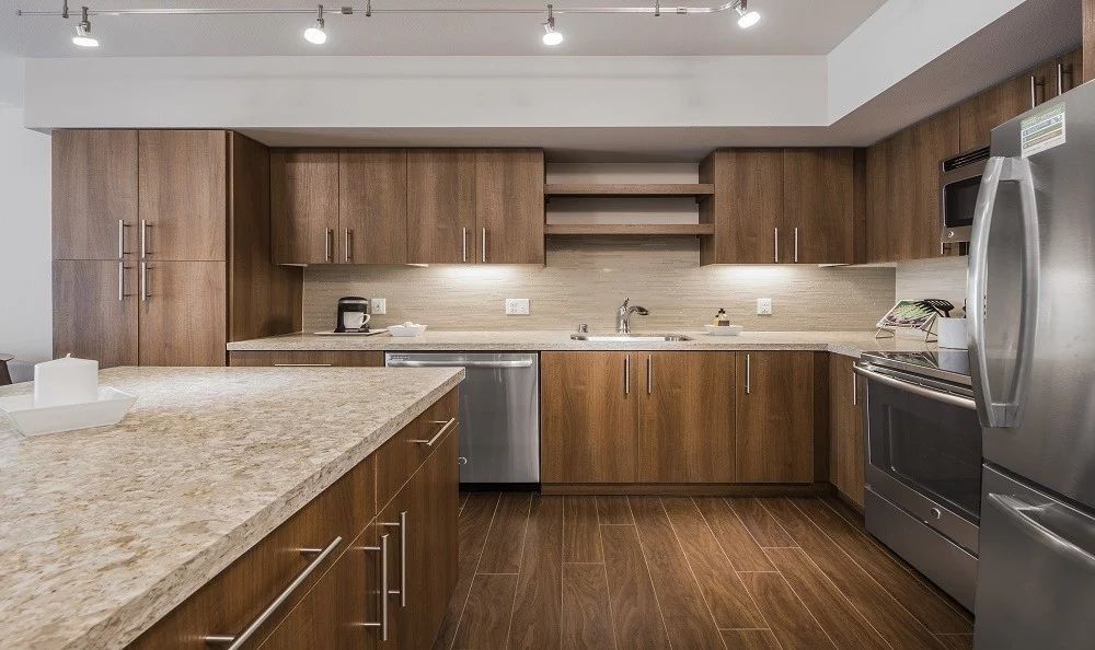 Modern kitchen with wood cabinets, granite countertops, and stainless steel appliances.