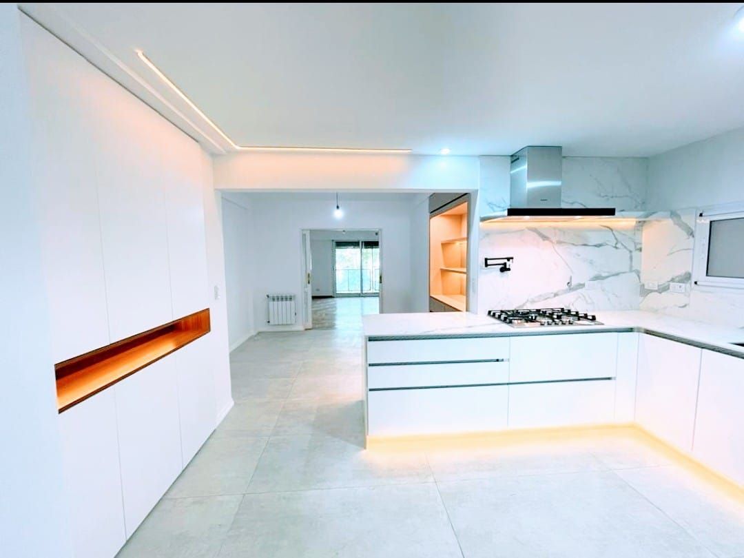 Una cocina con gabinetes blancos y un horno de estufa.