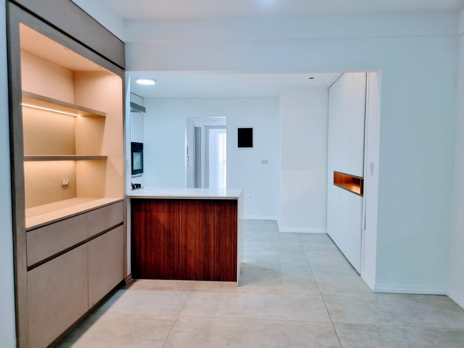 Una cocina con isla de madera y gabinetes blancos.