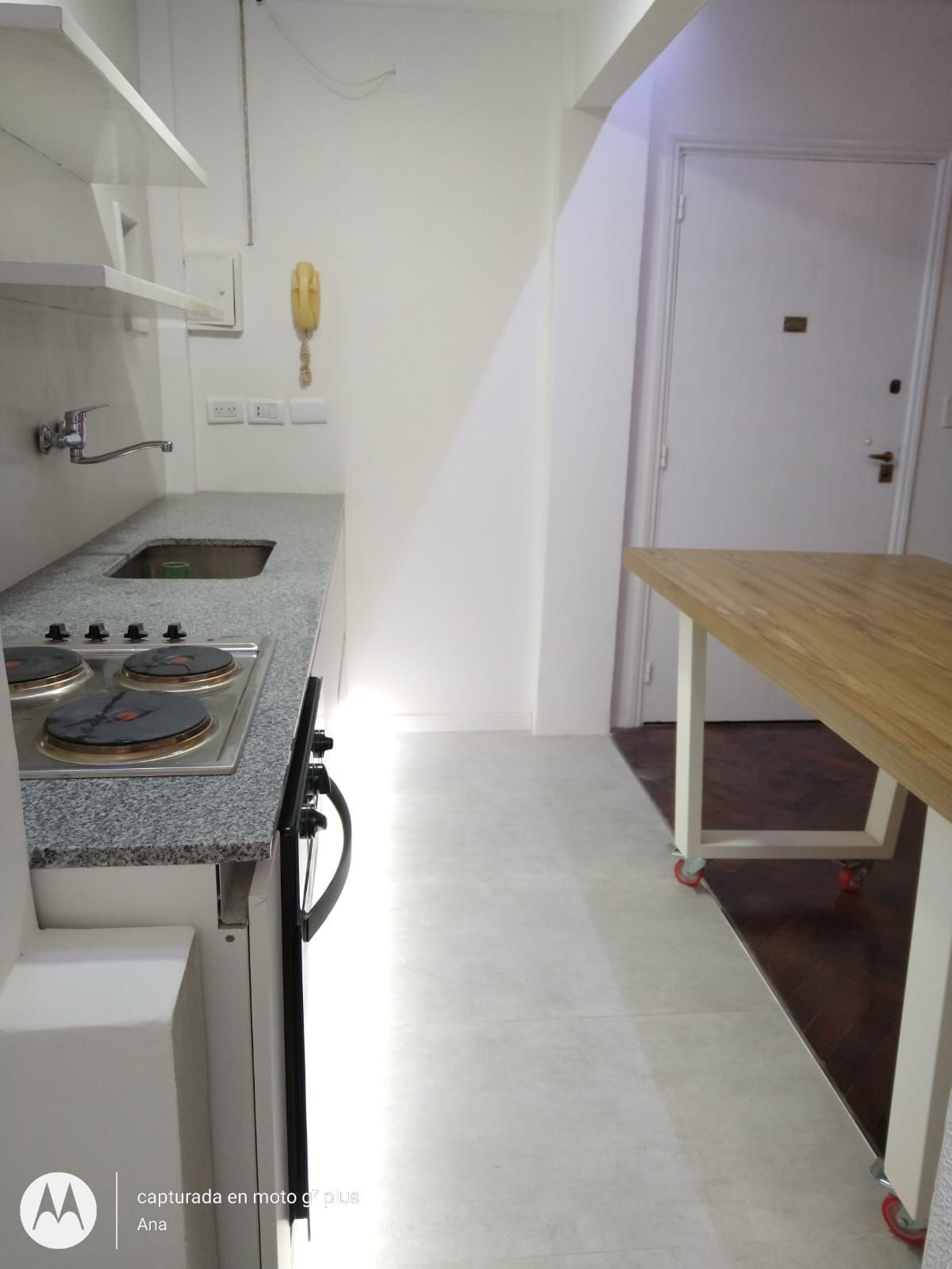 Una cocina con horno y una mesa de madera.