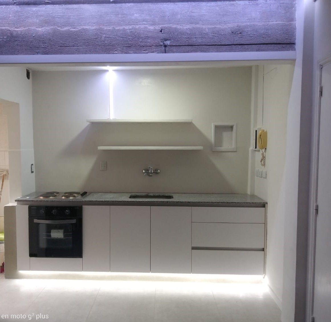 Una cocina con gabinetes blancos y un horno de estufa.