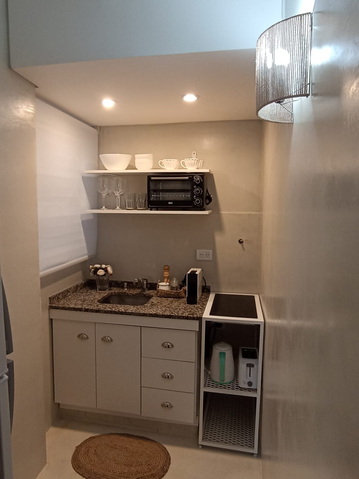 Una pequeña cocina con fregadero, microondas y estufa.