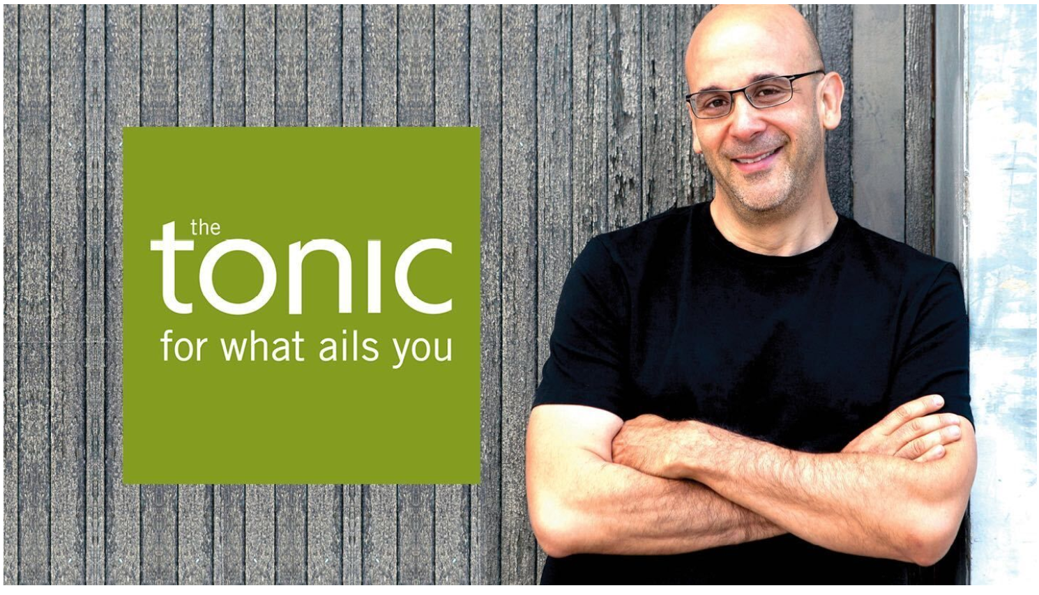 Logo reading “tonic for what ails you” beside a bald man in glasses with folded arms on a gray textured background
