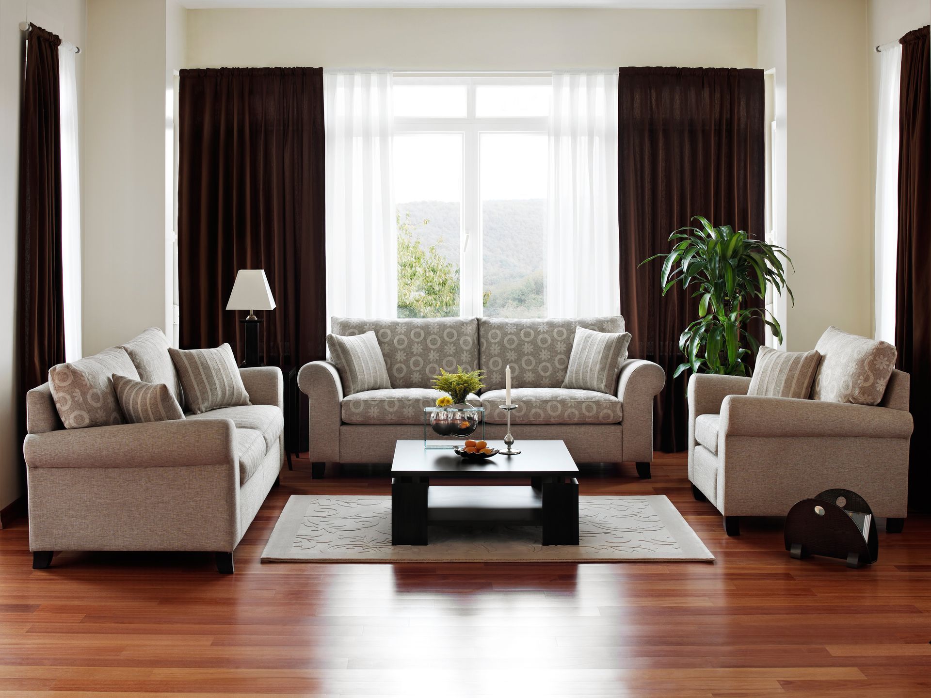 Living room set with beige sofas, a coffee table, and dark curtains.