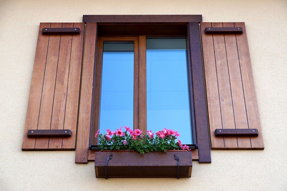 A Window With Wooden Shutters And Flowers In A Window Box — Northern Glazing Glass & Aluminium In Smithfield, QLD