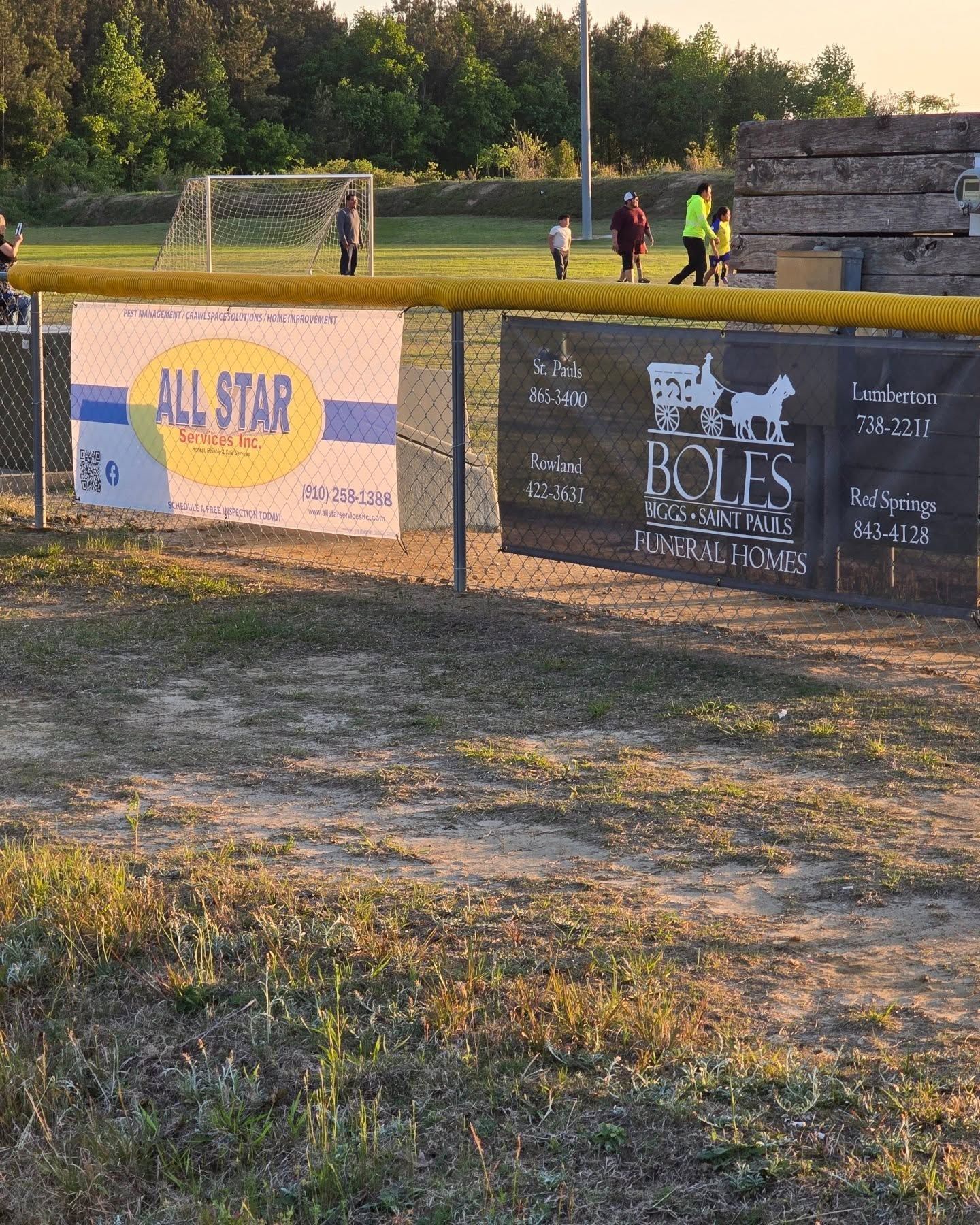 A fence with a sign that says ' holes real estate ' on it