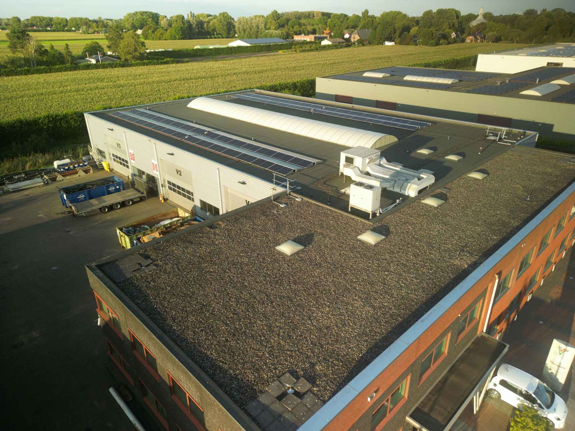 Een luchtfoto van een gebouw met zonnepanelen op het dak