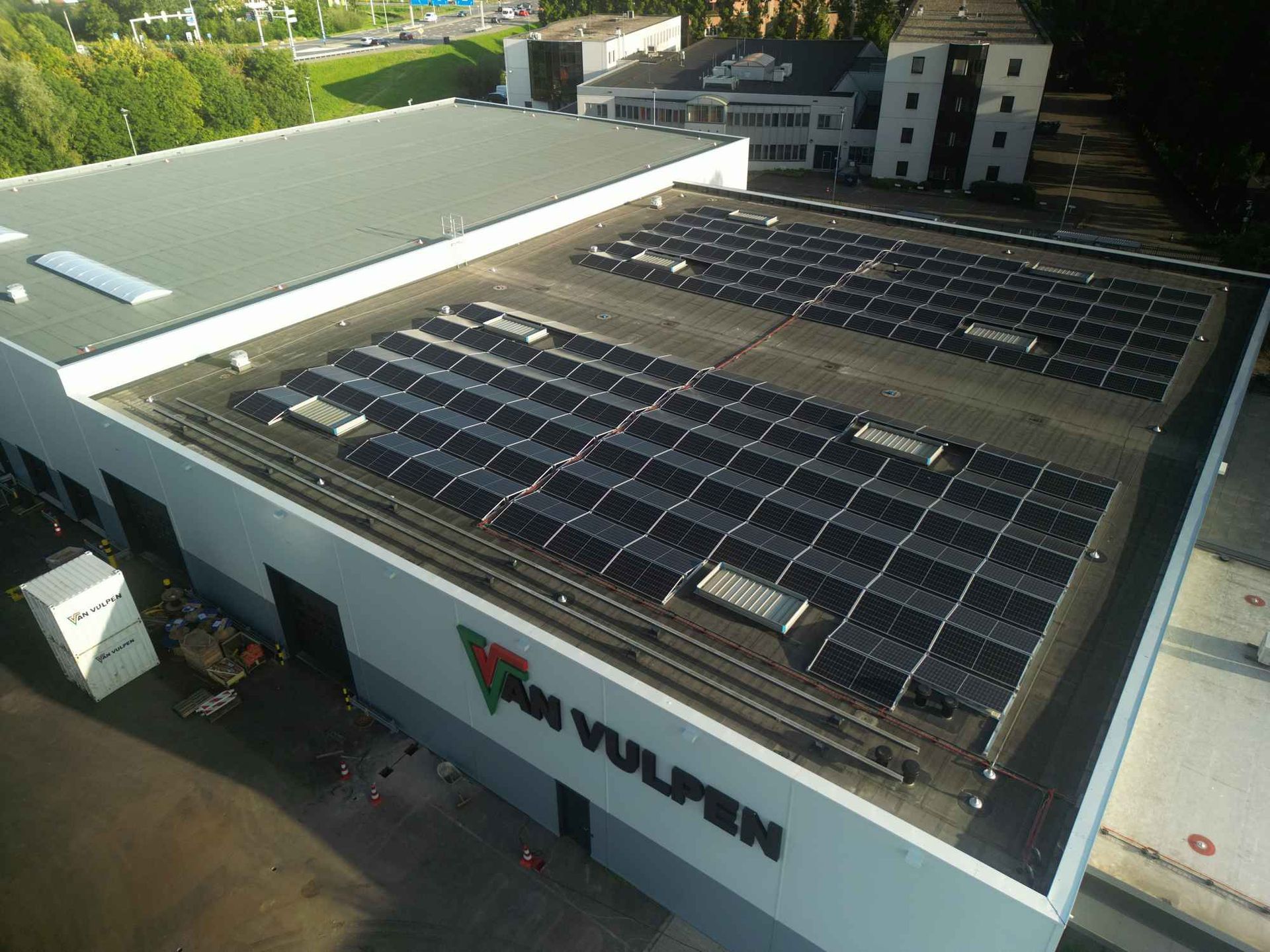 Een groot gebouw met veel zonnepanelen op het dak.