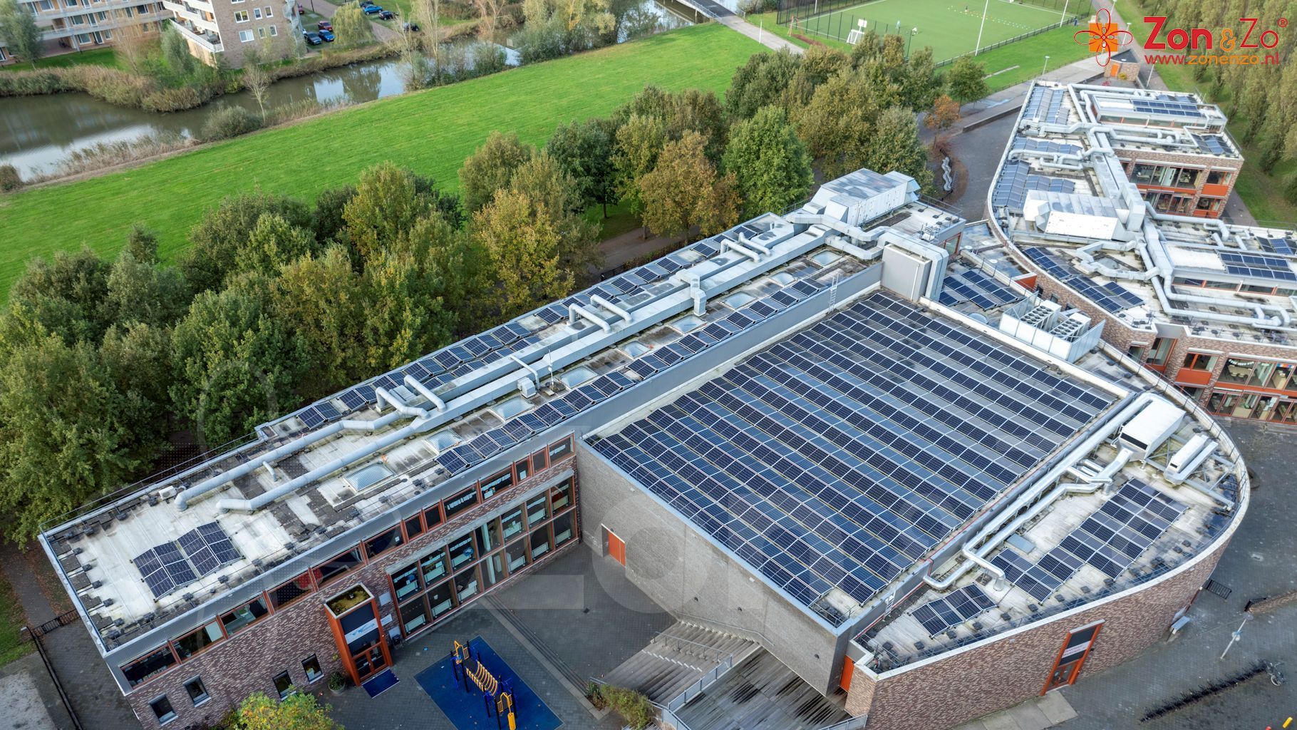 Een luchtfoto van een groot gebouw met zonnepanelen op het dak.