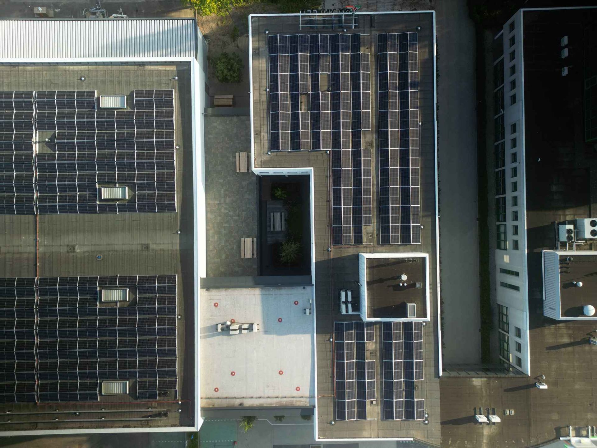 Een luchtfoto van een gebouw met zonnepanelen op het dak.