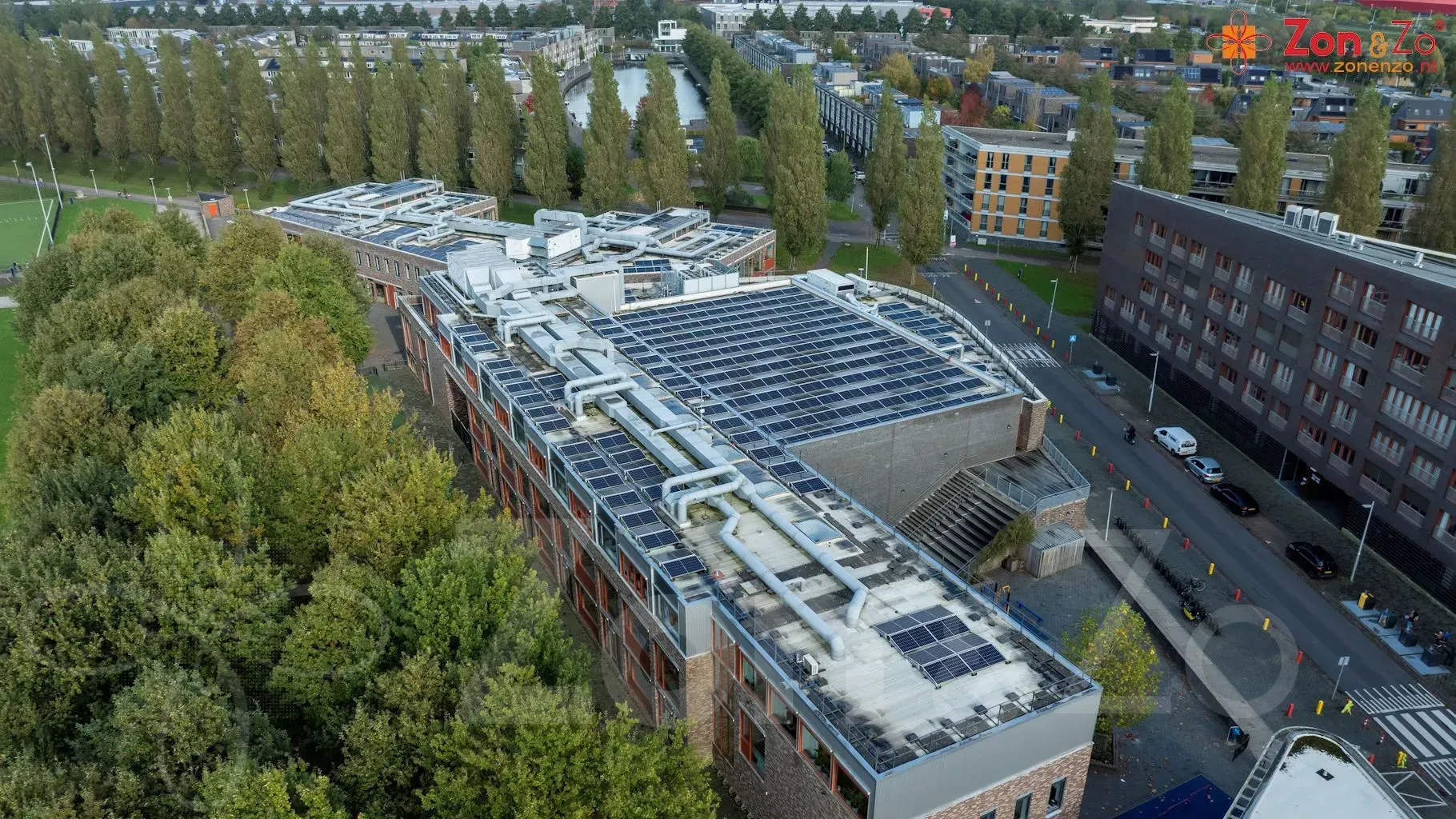 Een luchtfoto van een groot gebouw met zonnepanelen op het dak.