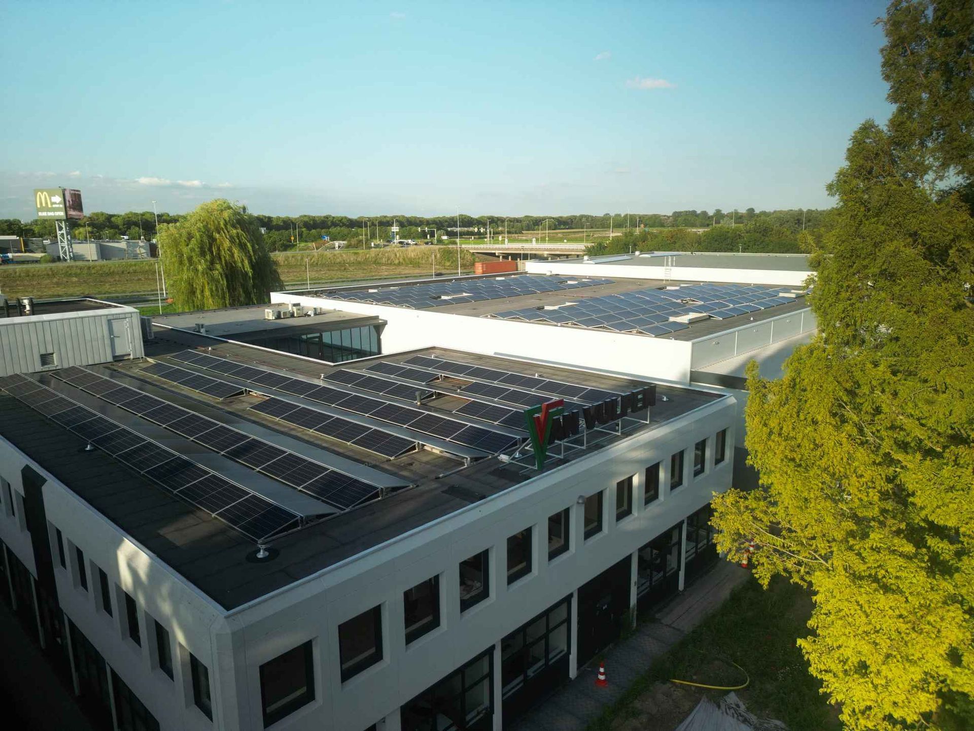 Een luchtfoto van een gebouw met zonnepanelen op het dak