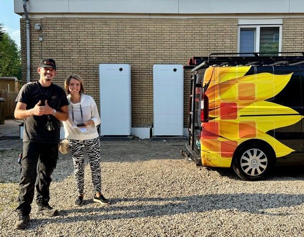 Een man werkt met een schroevendraaier aan een elektrische doos.